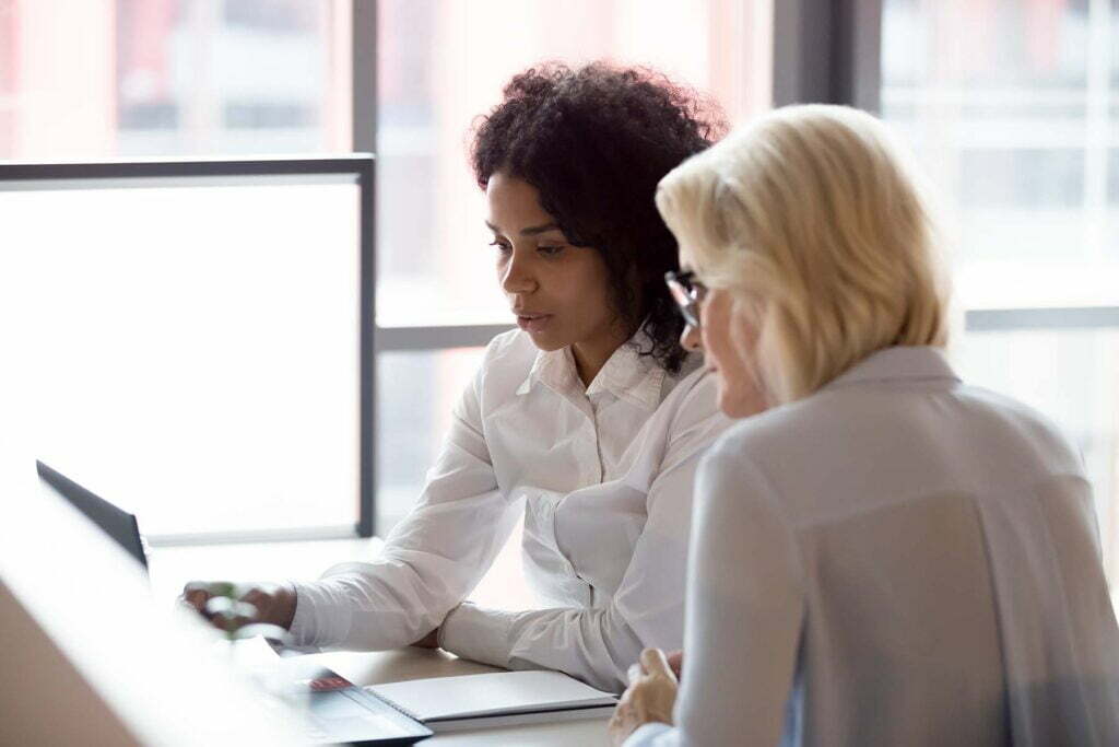 two people talking at a computer about their 401(k)