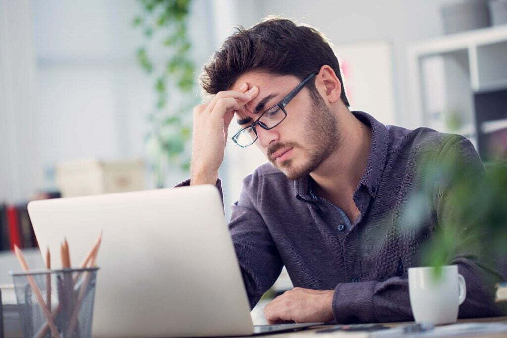 tired man at laptop doing his budget