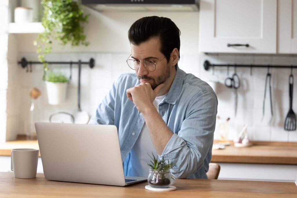 man thinking at his computer about COLAs fringe benefits