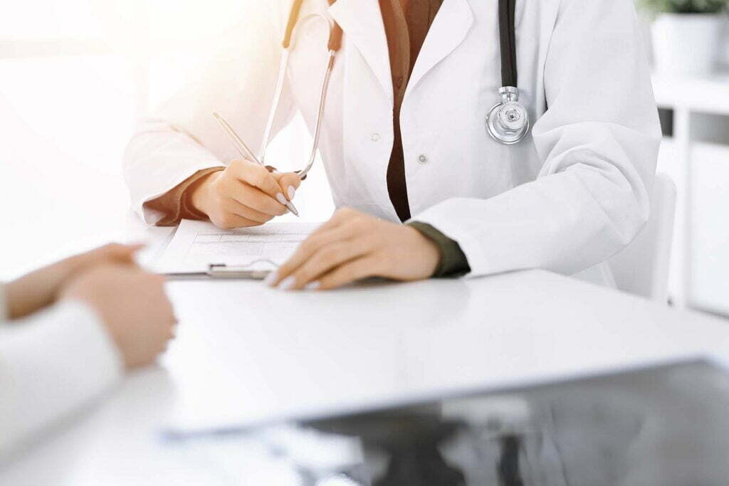 a doctor writing down things with a patient about health care