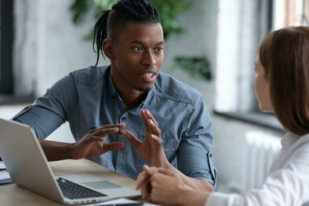two people talking about tax credit in front on laptop