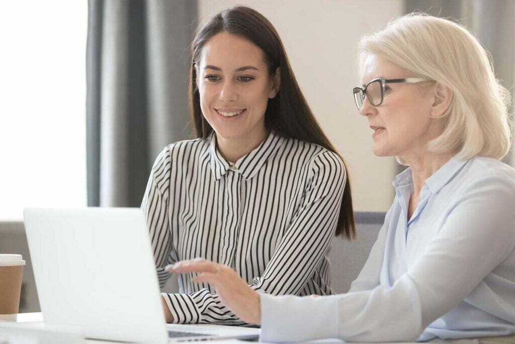 two people talking at a computer about tax filing