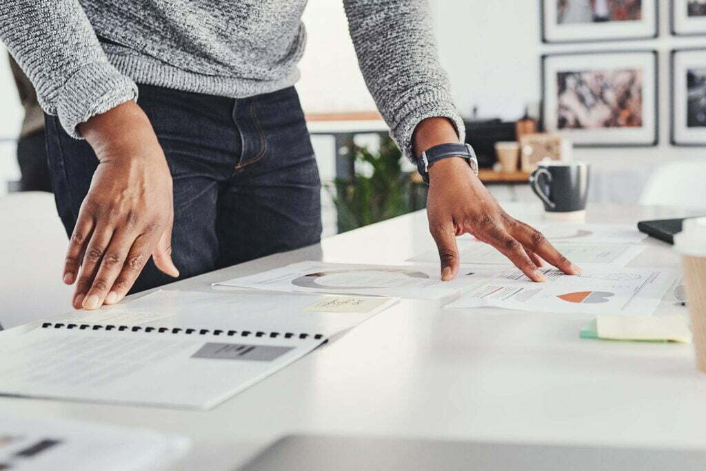 man standing over desk with tax papers on it