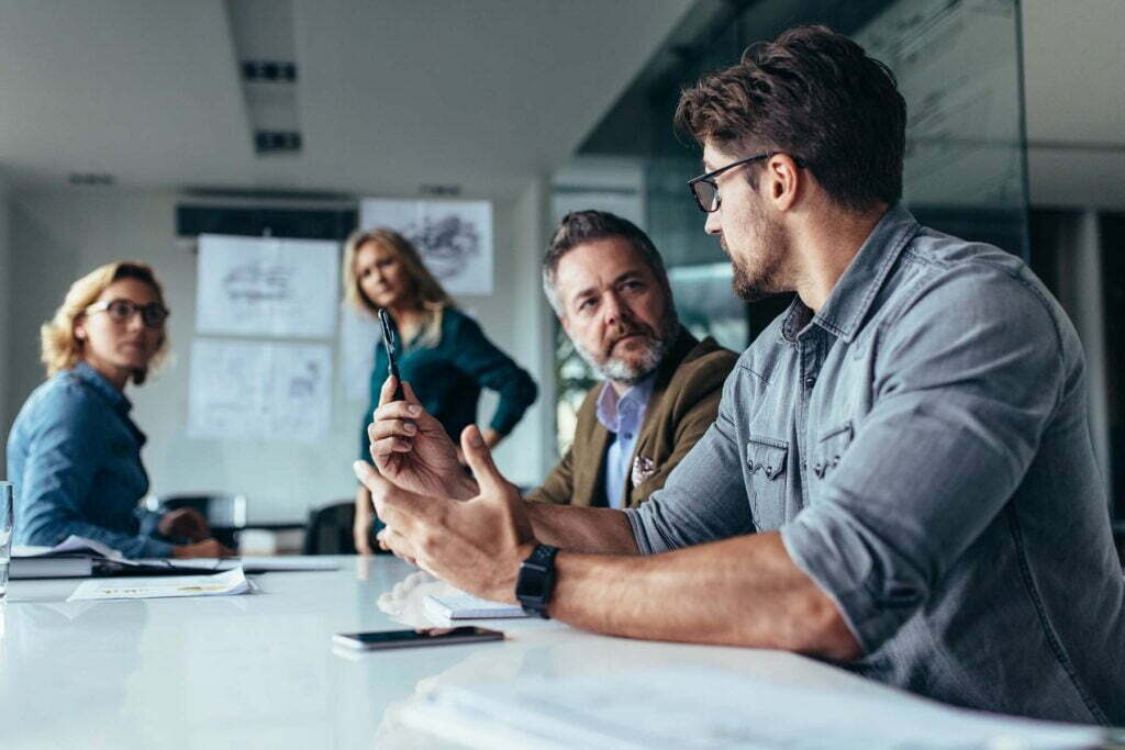 company man talking to coworkers in a meeting