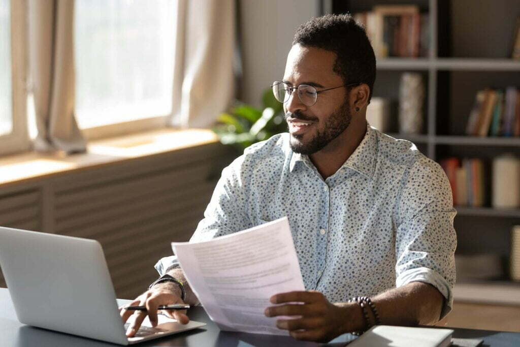 man with tax return paperwork at his computer