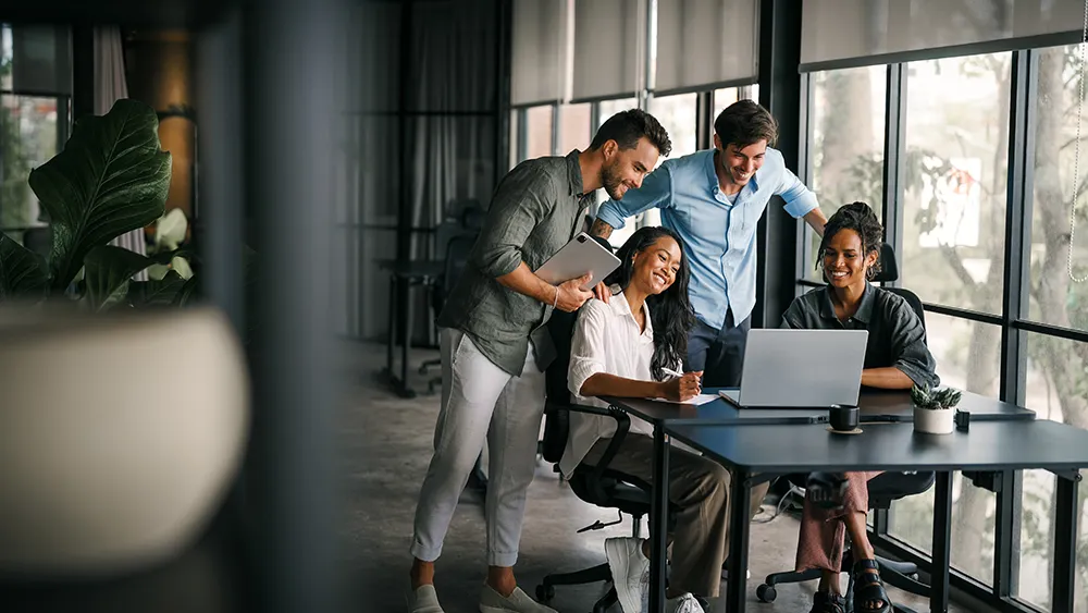 team of employees looking at a laptop
