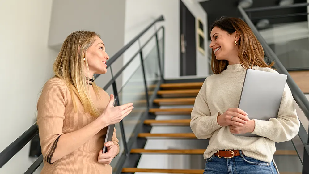 two women talking near stairwell